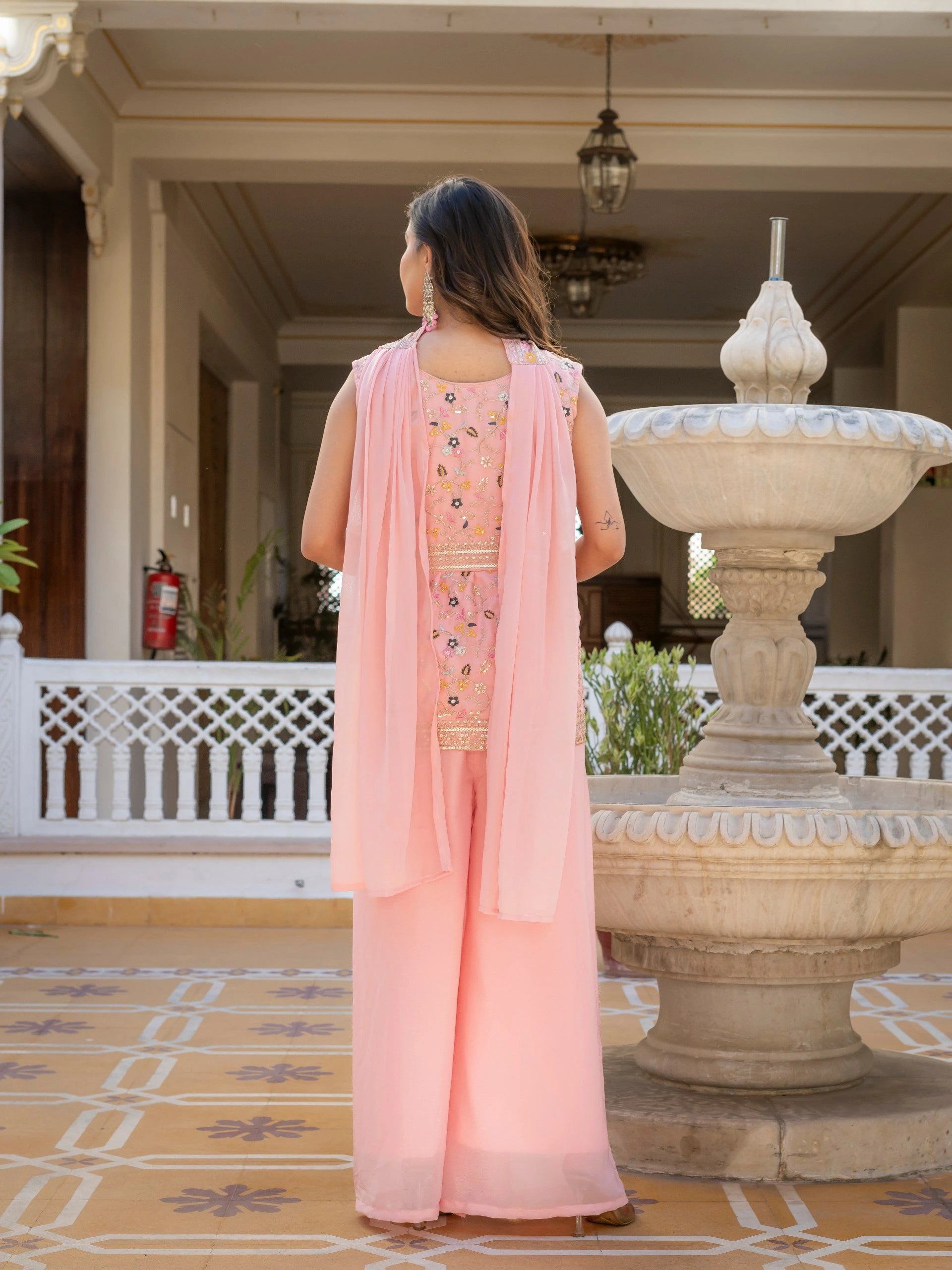 Full-length light pink embroidered georgette suit draped gracefully